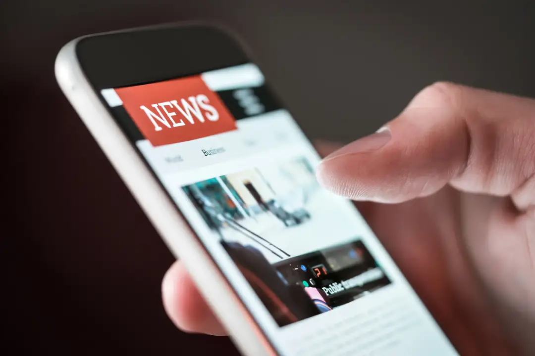 NewClose-up of a person reading online news on a smartphone screen, with a finger about to scroll Project NewClose-up of a person reading online news on a smartphone screen, with a finger about to scroll Project
